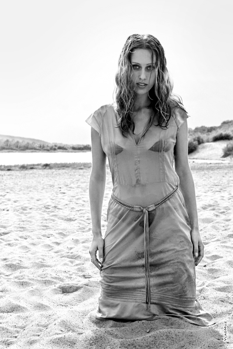 Фото девушки в мокром платье на песчаном берегу, стоя на коленях