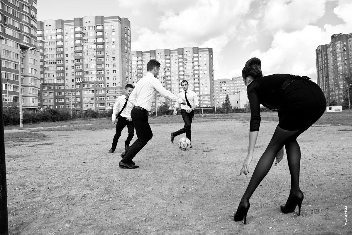 Фото красивой девушки в короткой юбке и 3-х юношей, играющих в футбол на улице