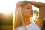 Портретное фото девушки-блондинки летом в контровом солнечном свете