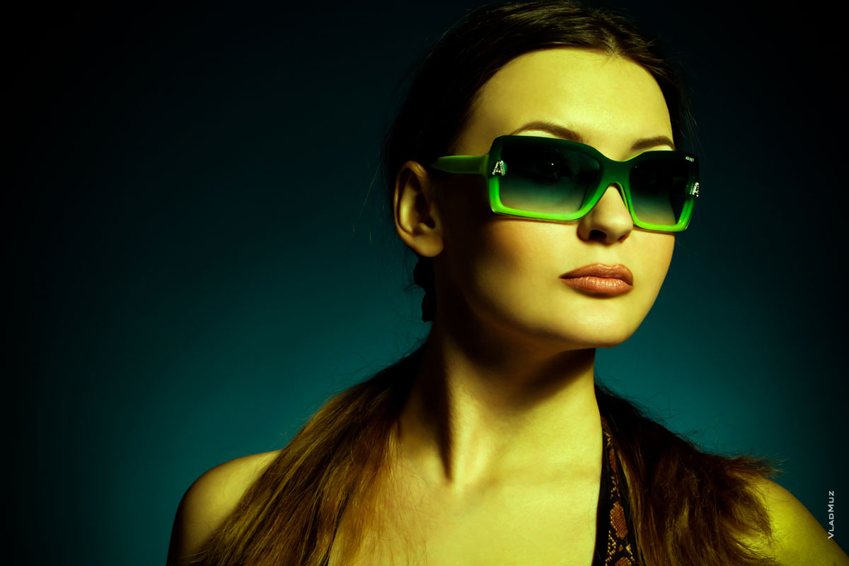 Горизонтальный фотопортрет девушки в солнечных очках в студии