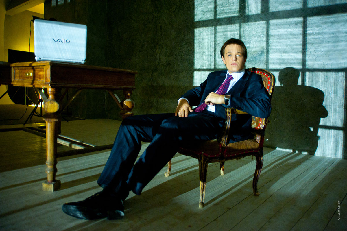# 08 Фото делового мужчины в костюме, сидя в кресле, в свете ночных городских огней