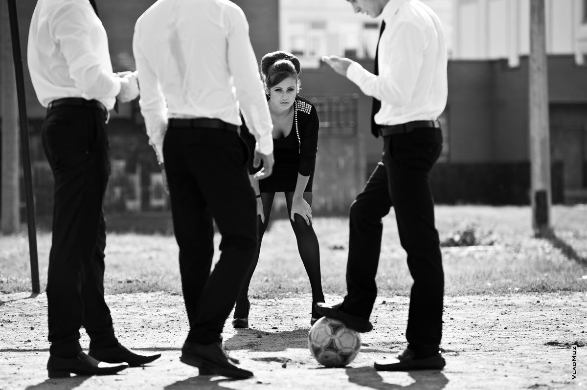 Фото красивой девушки на футбольных воротах среди юношей