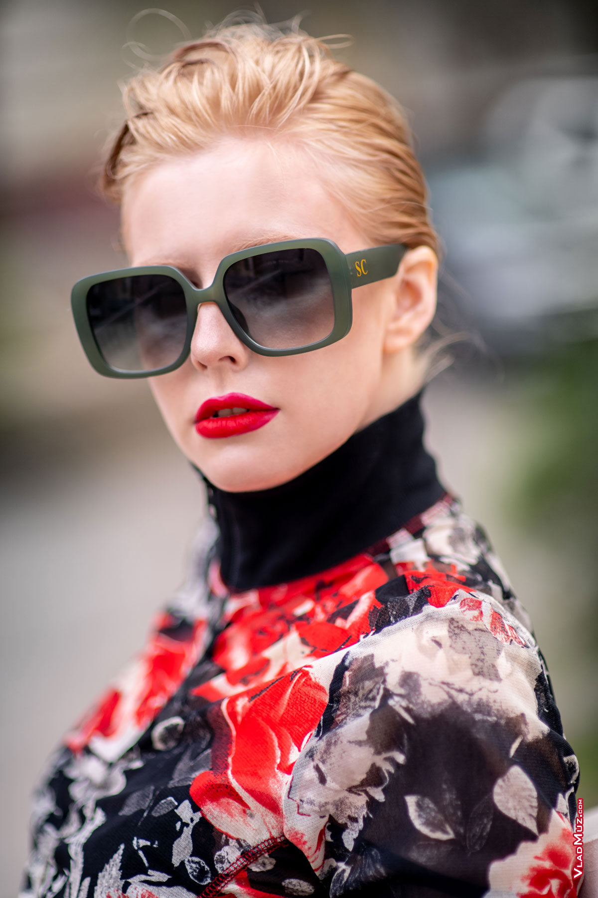 Модный грудной фотопортрет девушки-модели в солнцезащитных очках на улице в черно-красных тонах