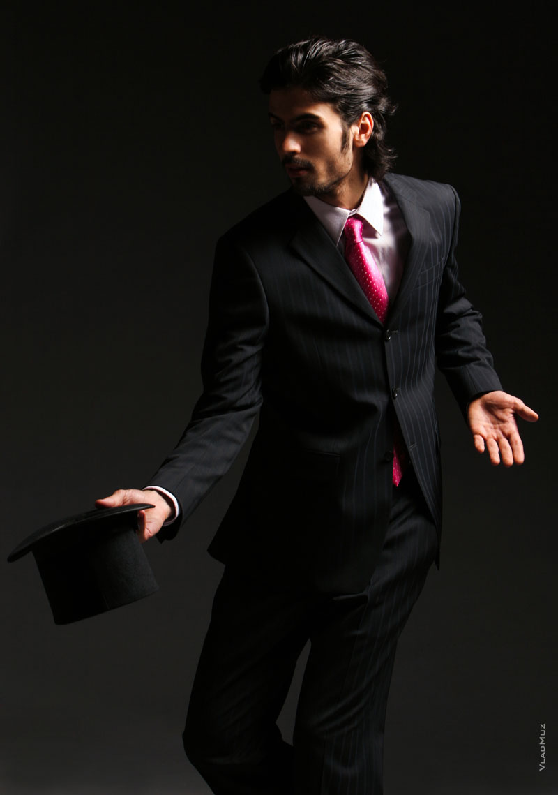 # 09 Динамичное студийное фото мужчины в костюме с галстуком, с цилиндром в руке