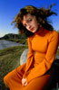 Фотопортрет девушки-модели в оранжевом платье на фоне синего неба